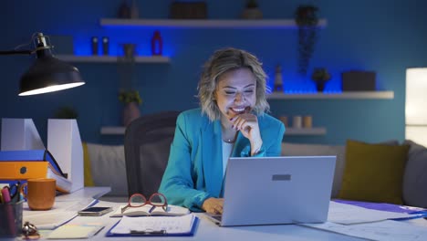 una donna che lavora in ufficio a casa che si diverte a lavorare sul portatile, a usarlo.