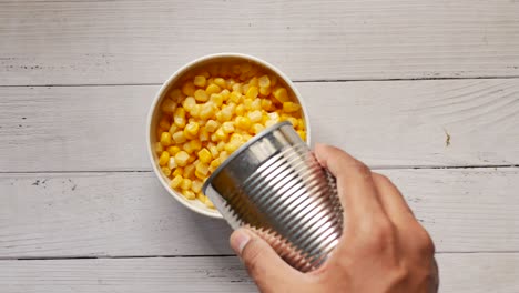 pouring canned corn into a bowl