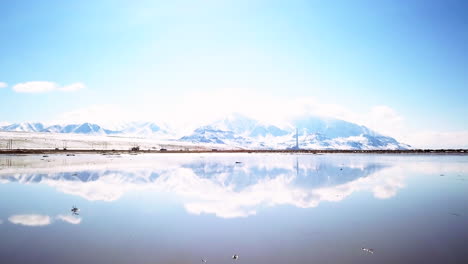 morning light mirror reflection of mountain scape and i80 highway with cars and trucks on salt lake slc utah cinematic forward motion