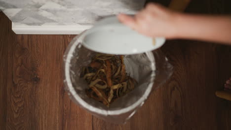 throwing potato peels in the trash can