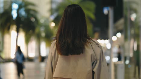 woman walking at night in a city