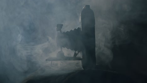 white smoke behind a very old vintage folding camera from 1910 in a dark room