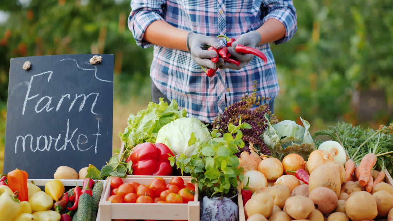 un vendedor en una feria agrícola pone verduras en el mostrador
