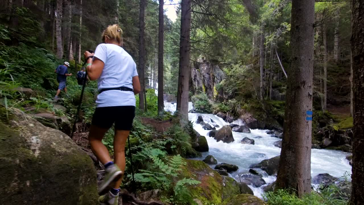 트레킹 투어를 하고 있는 한 여성의 초상화, 그녀는 산길을 고 있습니다.