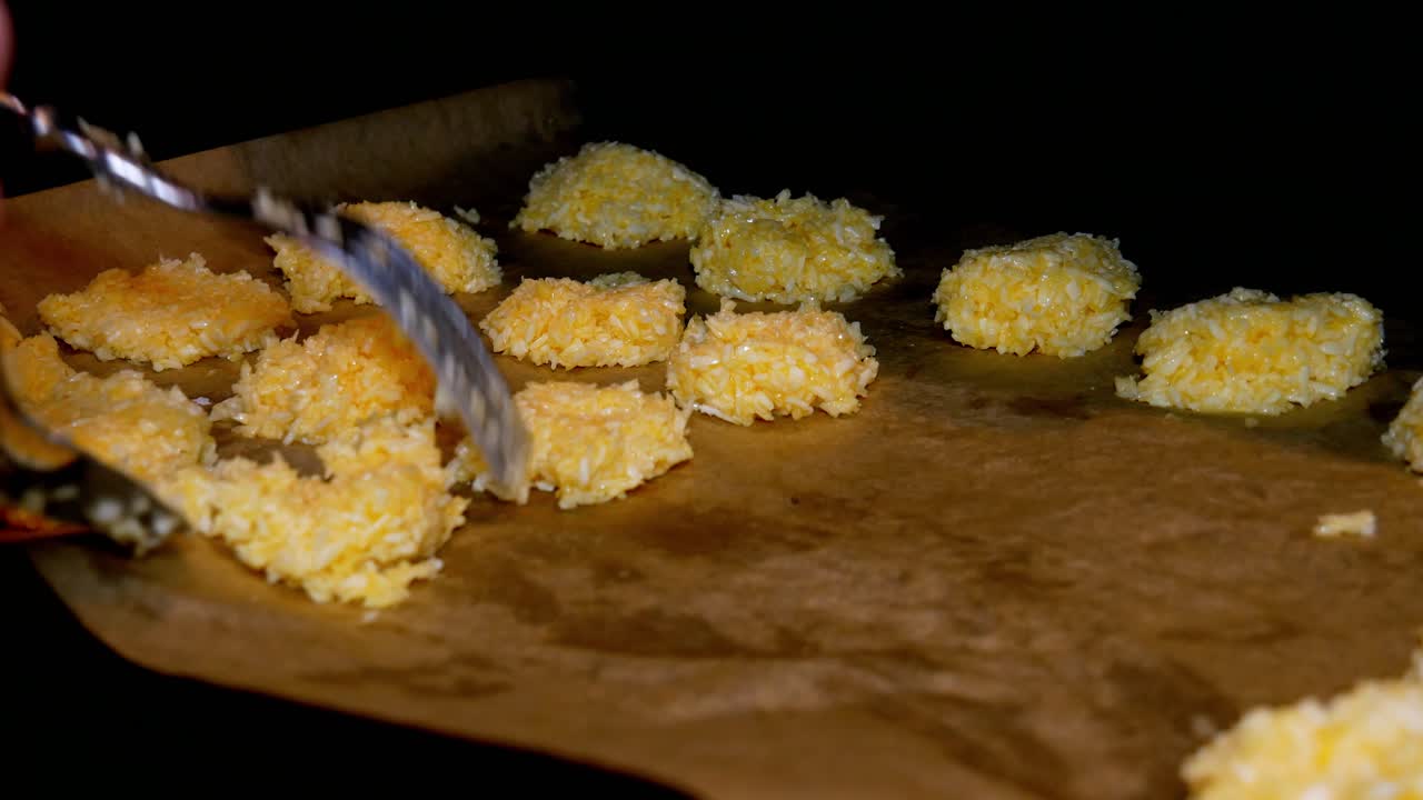美味しいお菓子を作るため、ベーキングシート上でココナッツクッキーを成形しオーブンで焼く