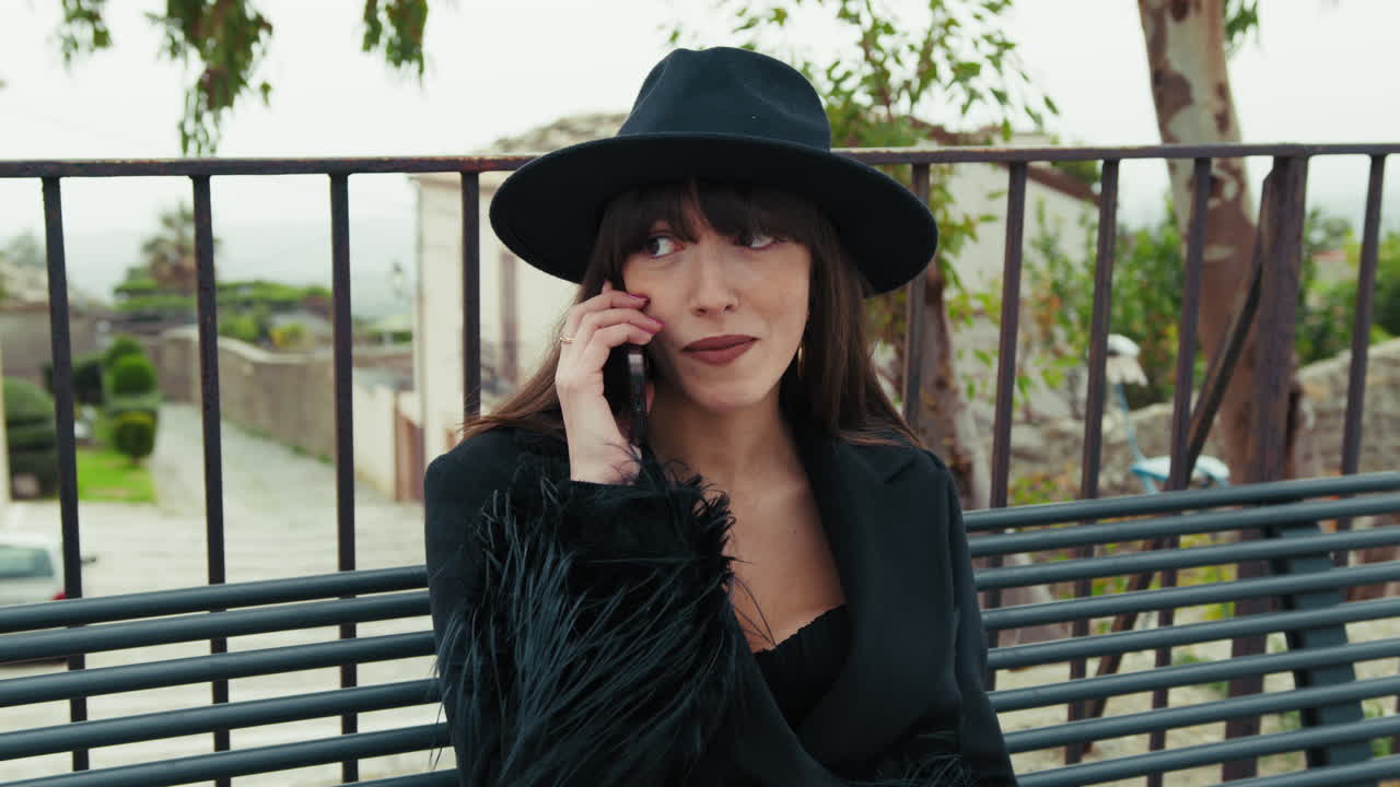 Woman In Elegant Dress On The Park Bench Having A Call With A Friend