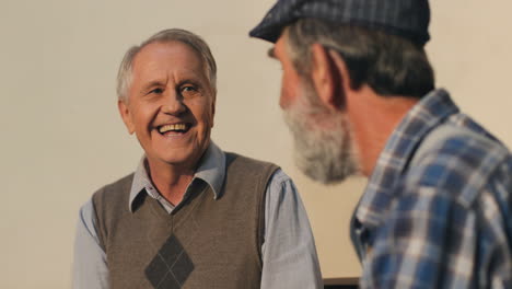 Close-Up-Of-The-Two-Cheerful-Retired-Men-Laughing-And-Chatting-Outdoors