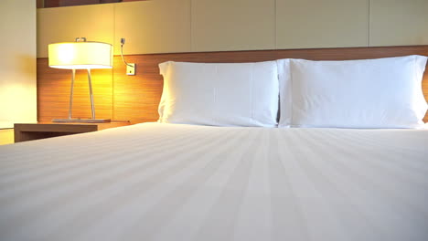 white bed setup and lamps in cozy bedroom of luxury hotel, close up pan