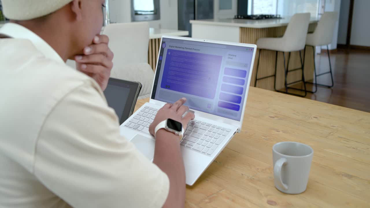 Student is viewing purple app on laptop, tapping and scrolling at dining table to select items