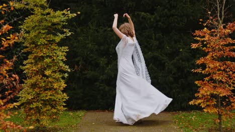 tall woman in a beautiful long dress dancing outside in the rain