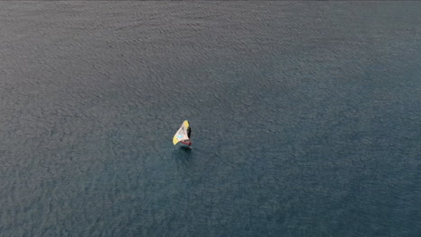 Drohne-Schoss-Von-Hinten-Auf-Einen-Mann,-Der-Im-Meer-Windsurfte