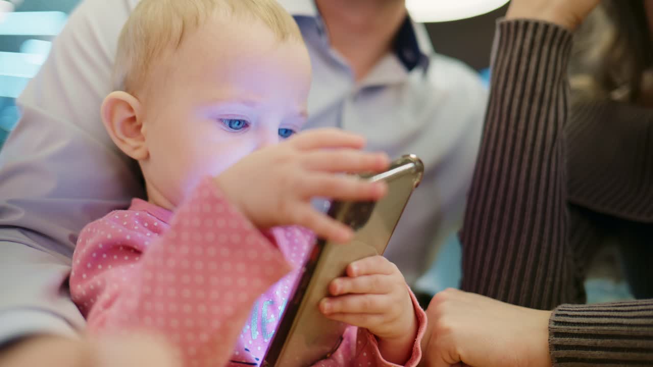 光るスマートフォンの画面を持つ赤ちゃんのクローズアップ