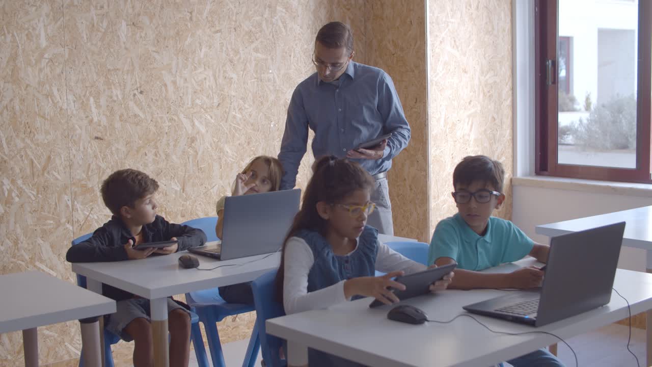 profesor de informática comprobando cómo los alumnos completan la tarea