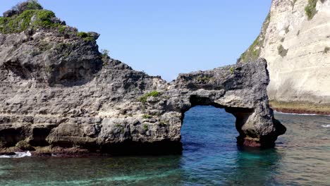 Atuh-Beach-natural-arch-in-Nusa-Penida-island,-Aerial-approach-shot