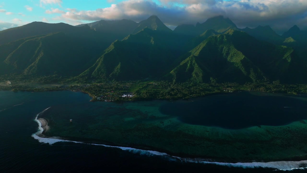 Tahiti lagoon landscape aerial drone harbor view French Polynesia Teahupo'o surf wave Passe Havea coral reef South Pacific Ocean island golden light rays volcano peaks beach coastline backwards pan