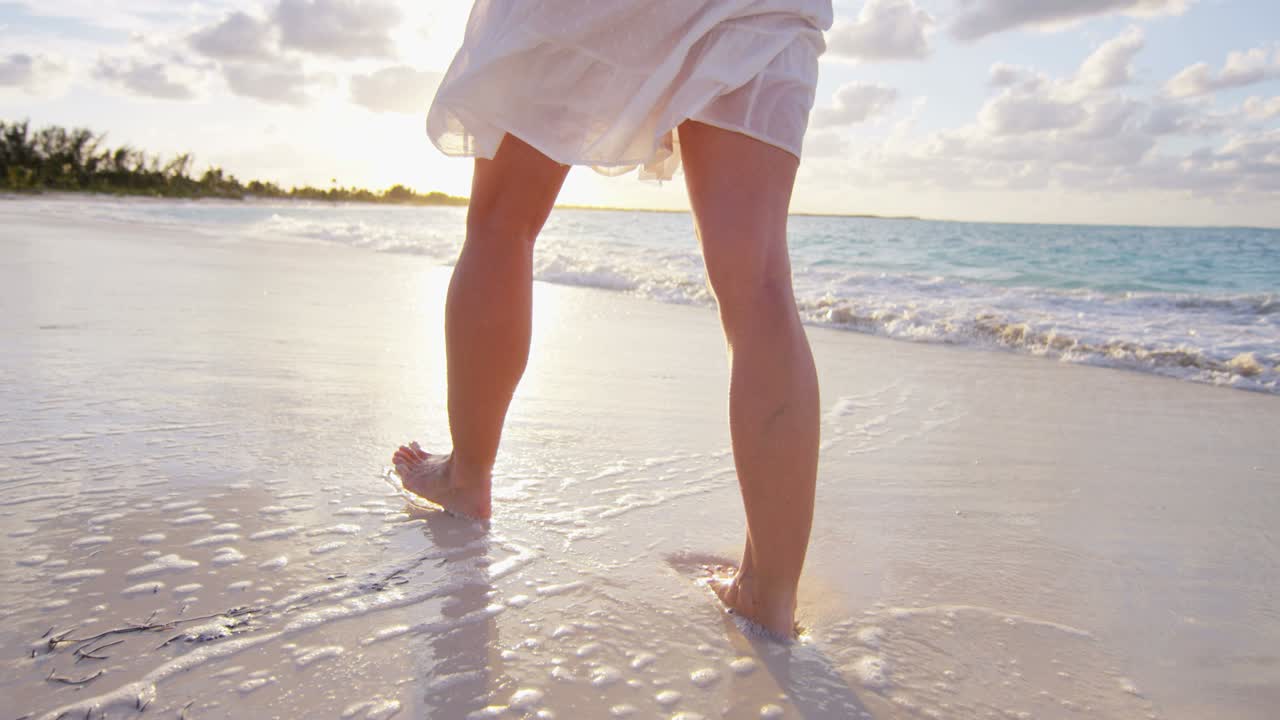 해가 지는 해변에서 벌거벗은 여성 백인 다리