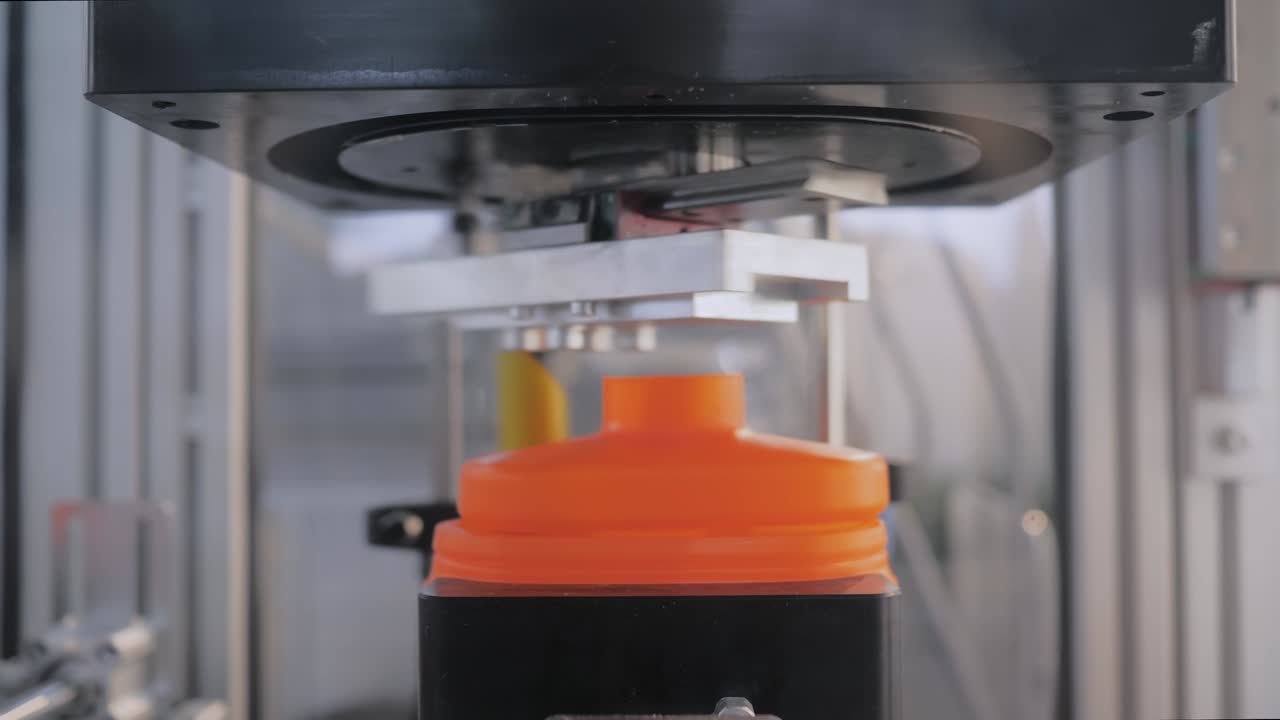 cortador de rodaje de cúpula que corta recipientes de plástico naranja vacíos en la cinta transportadora