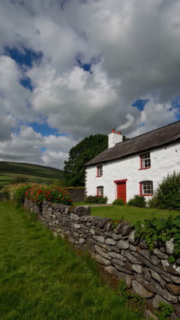 a charming white cottage with a red door in a scenic rural landscape