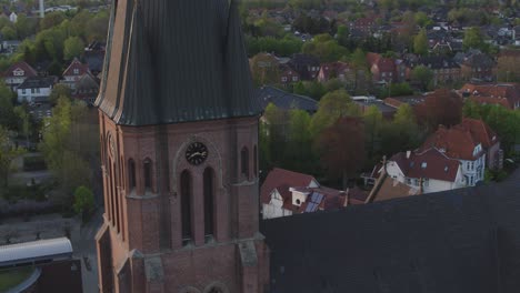 drone flight around a church in north germany with the sunset