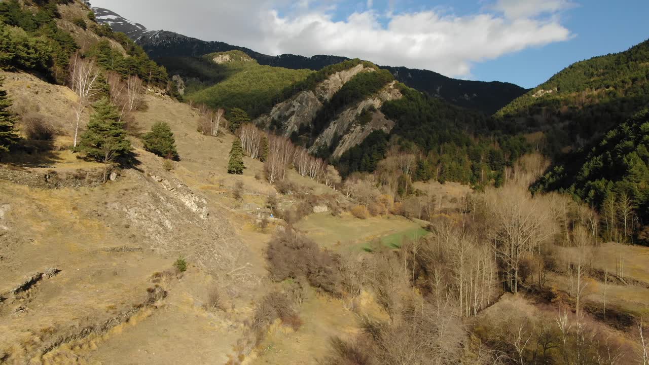 Aerial view of rugged Andorran mountain landscape with sparse trees and cloudy sky. Untouched Pyrenees nature, hiking destination, scenic beauty