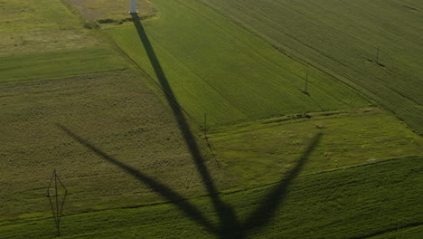 rotating wind turbine blades casting shadow on fields in gori, georgia