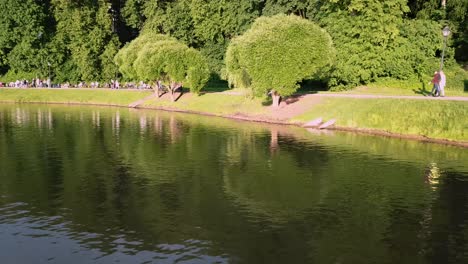 escena del parque con personas y reflejo de agua
