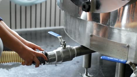 trabajadora chequeando una tubería en una fábrica de destilería 4k