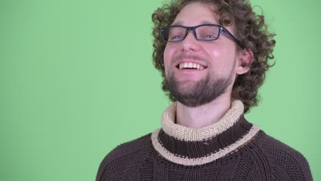 un joven guapo con barba y cabello rizado.