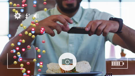 interfaz de cámara digital y emojis faciales contra hombre afroamericano tomando una foto de su comida