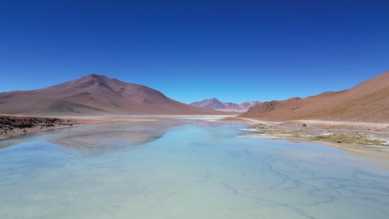 Low flight over shallow lagoon in high altiplano mountains of Bolivia
