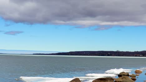 cielo azul claro en el horizonte, con nubes oscuras formándose en lo alto