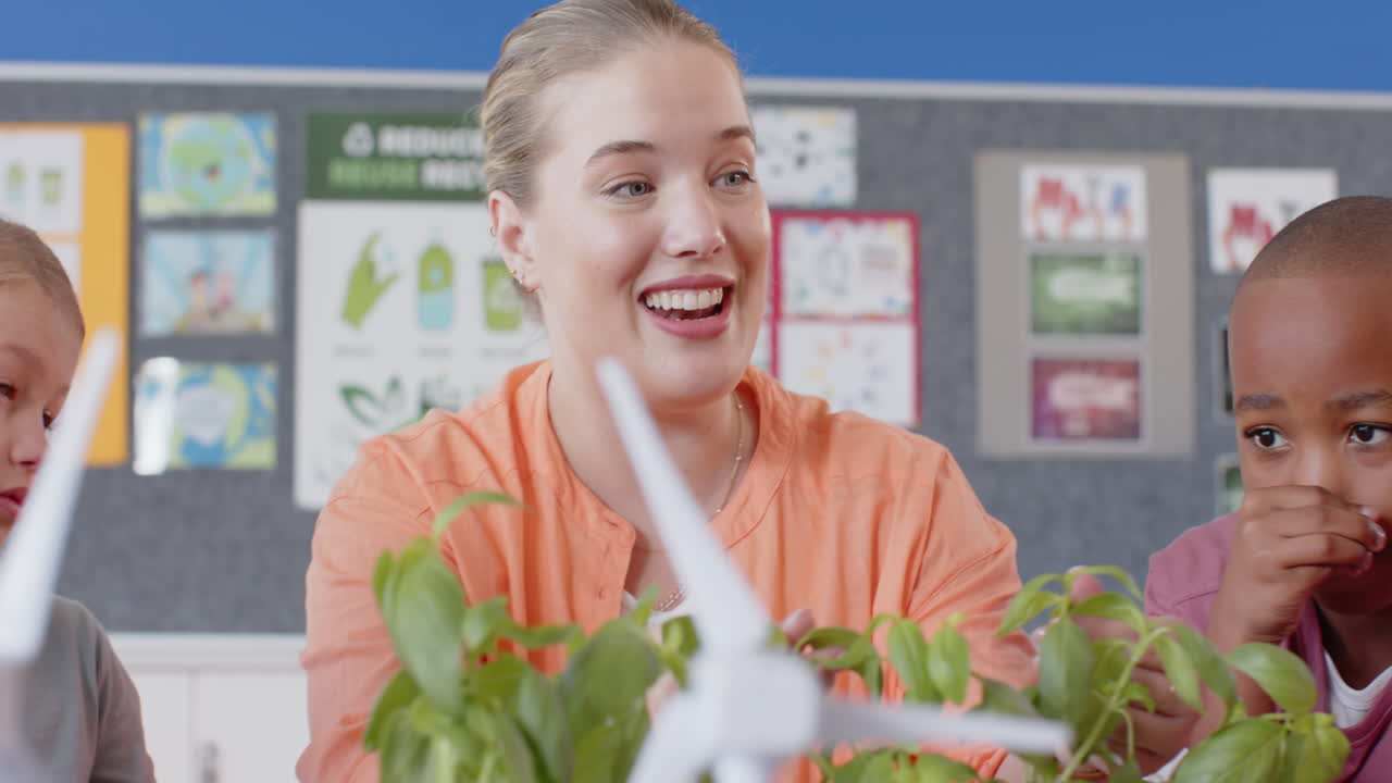 female teacher and students in school learning about renewable energy with wind turbines