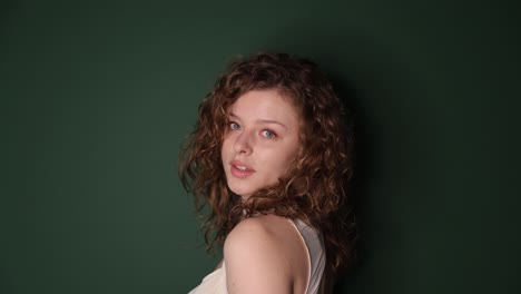 a beautifully serene portrait showcasing a young woman with curly hair set against a vivid green a beautifully serene portrait showcasing a young woman with curly hair set against a vivid green background
