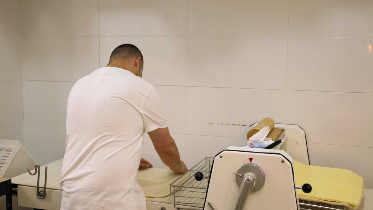 Baker Operating Dough Sheeter Machine in Commercial Kitchen