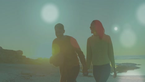 animation of light spots over caucasian couple at beach