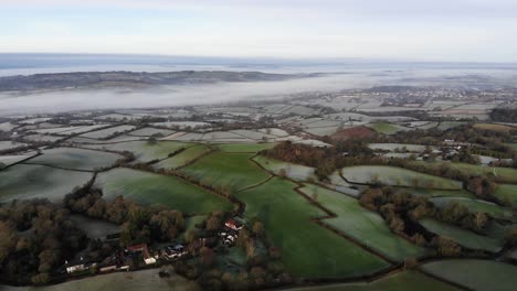 aerial backwards shot of the devon countryside england on a misty morning