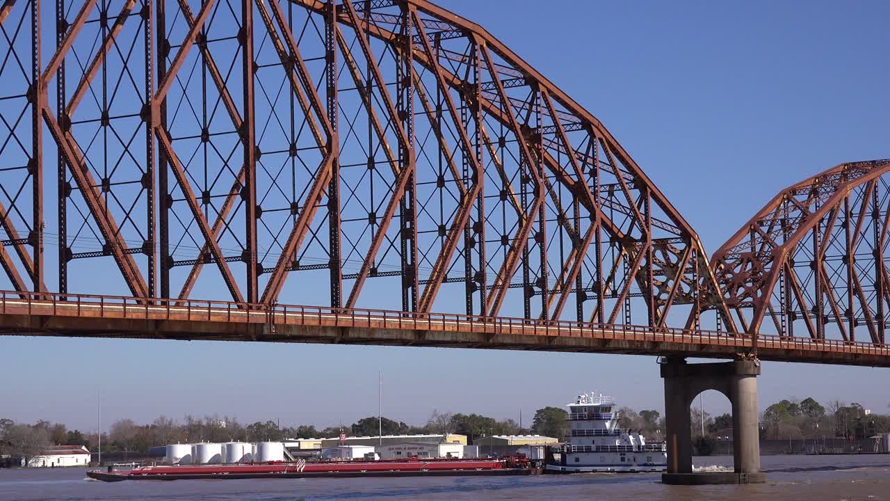 High water along the Atchafalaya Bridge and guard house in Morgan City Louisiana with a barge passing underneath
