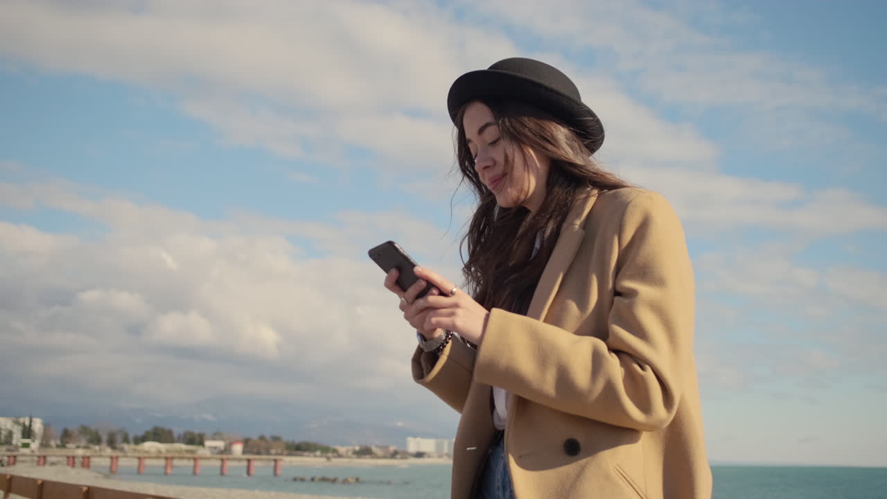 mujer usando un teléfono inteligente en la playa