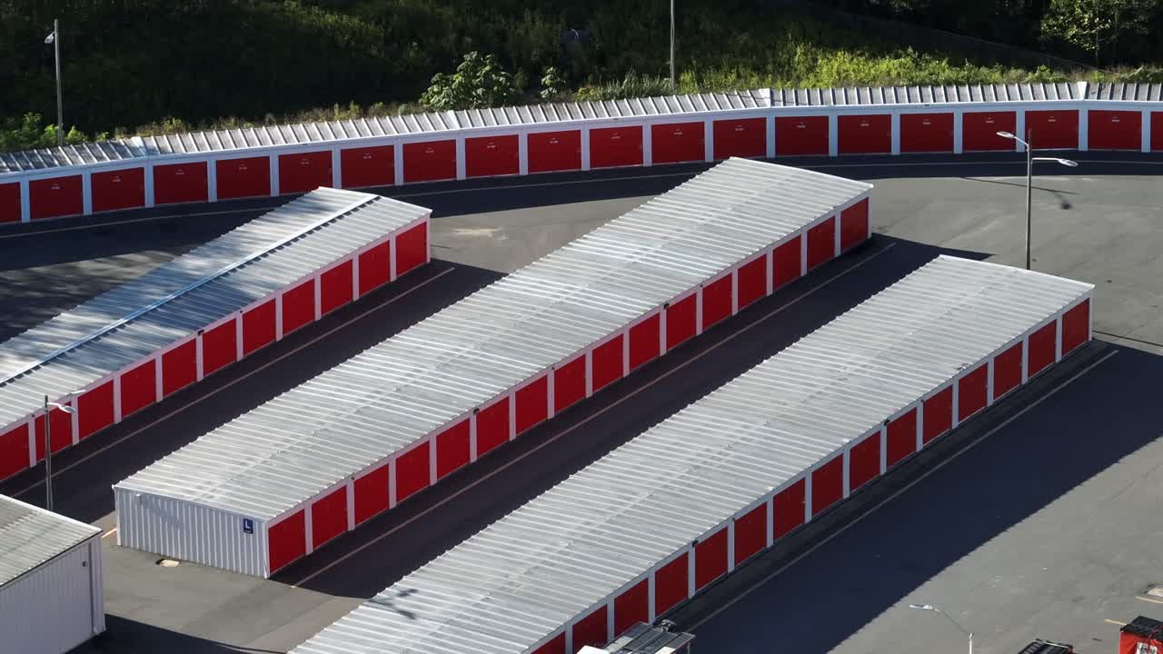 Row of red garages in industrial area. Aerial top down shot. Self storage unit buildings in America. Sunny day in autumn. Large area for rent