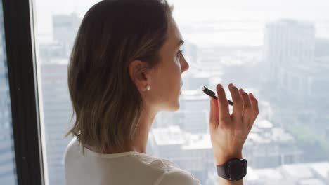 perfil de mujer de negocios caucásica pensando en la ventana de la oficina