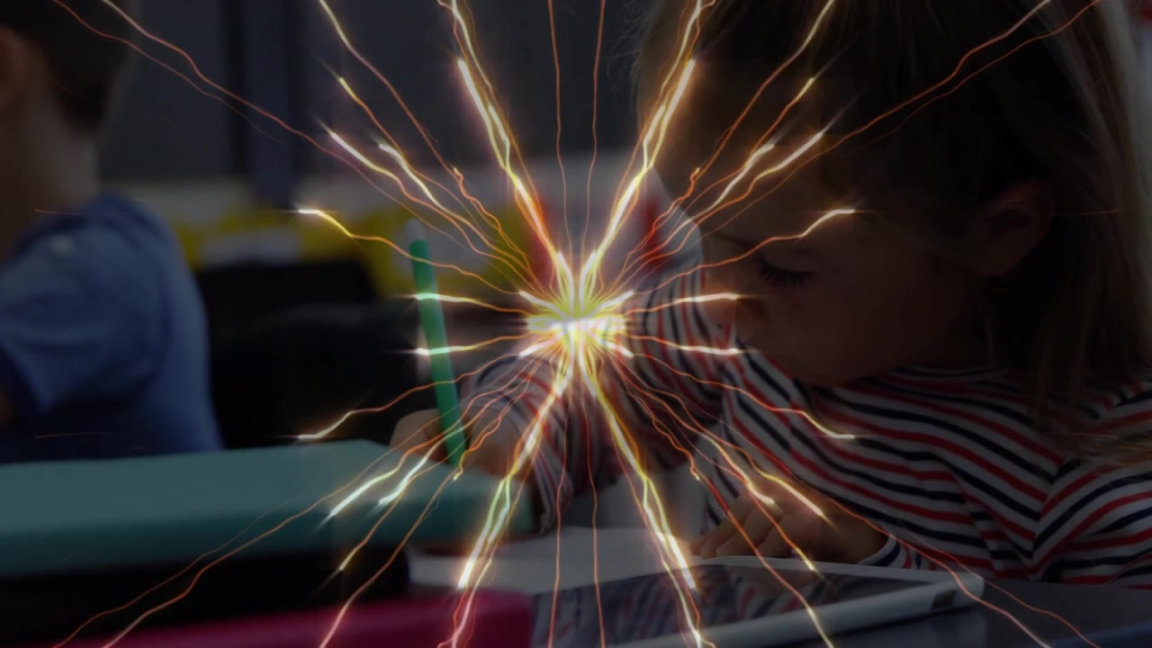 Girl lifting pencil and starting writing in school referencing tablet with starburst overlay