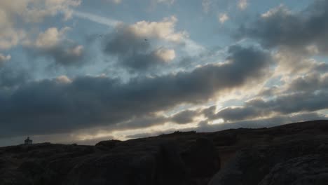 timelapse of moving clouds above portugal rocky coast, praia de norte or north beach