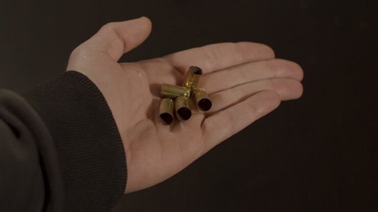 Mano che apre e rivela bossoli da 9mm.