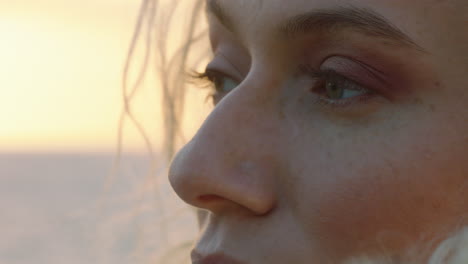 close up portrait of beautiful blonde woman enjoying peaceful seaside at sunset contemplating journey exploring spirituality feeling freedom with wind blowing hair