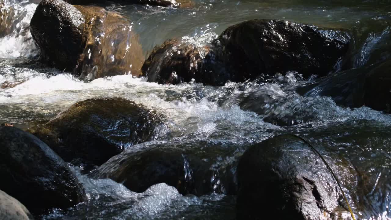 Acqua che scorre tra le rocce, producendo suoni e bolle d'acqua bianche