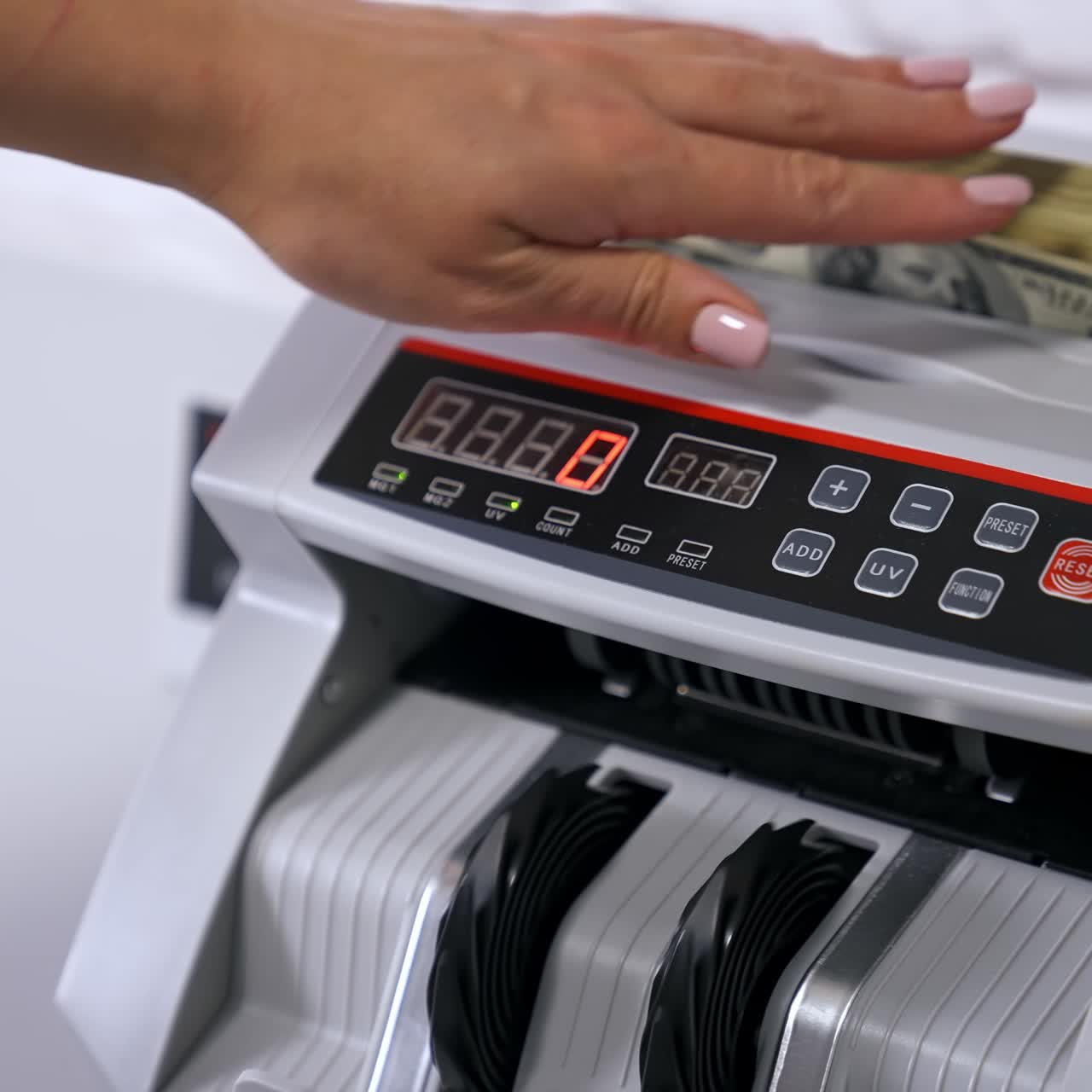 Money counting equipment for paper money calculation. Woman puts a pack of dollar banknotes to count. Automatic mechanism for bank financial operations