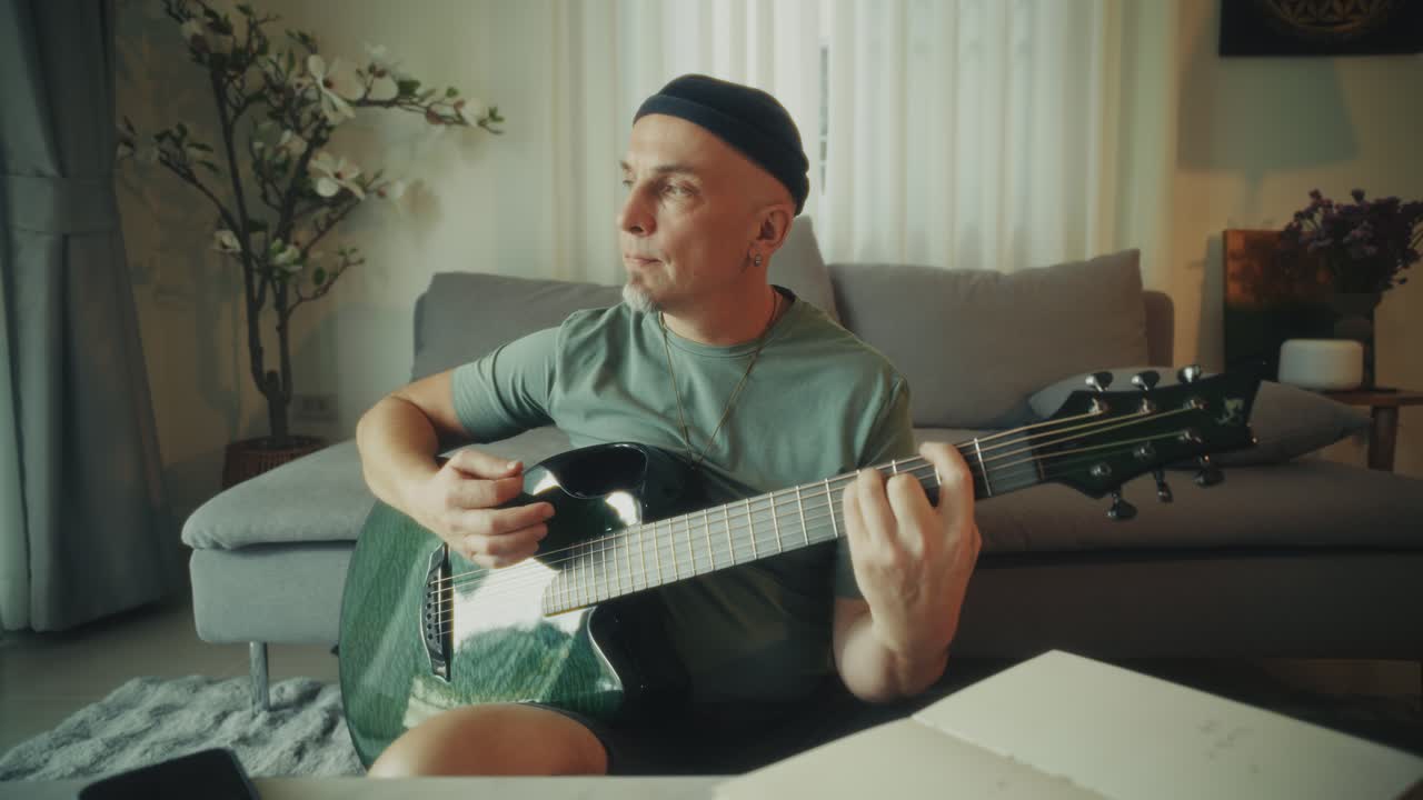 Homem Tocando Violão Acústico e Compondo Música em Casa