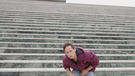 young man dancing on stairs while listening to music