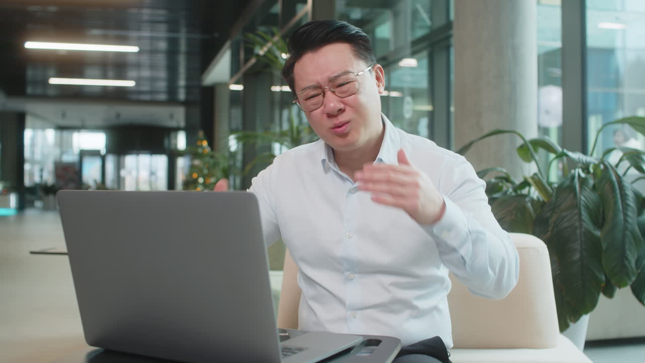 Sad businessman using laptop loses becoming shocked sudden lottery results in modern hotel lobby