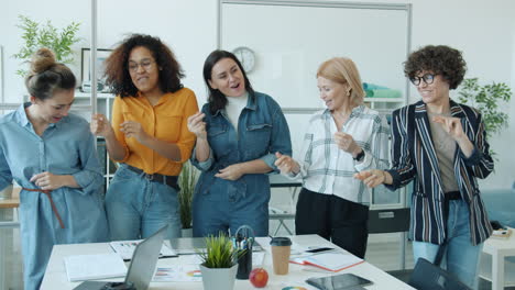 happy women dancing in office